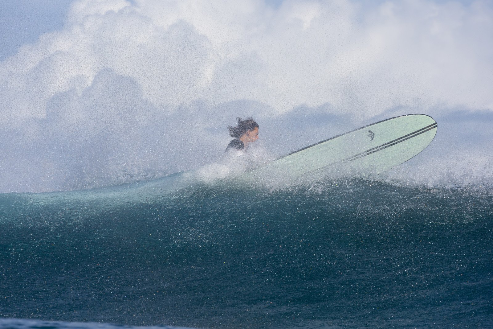 Surfer auf Delpero Longboard Pro mit Spray