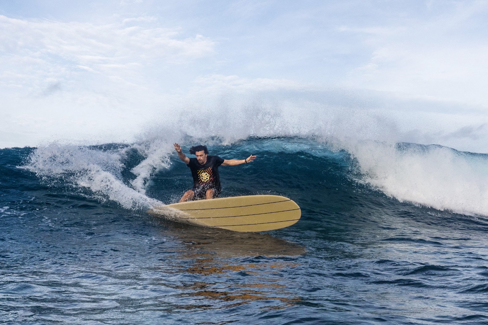 Surfer on Delpero Longboard Classic during a radical turn