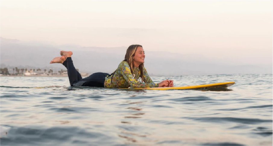 Surferin mit Sisstrevolution Wetsuit liegend auf Longboard